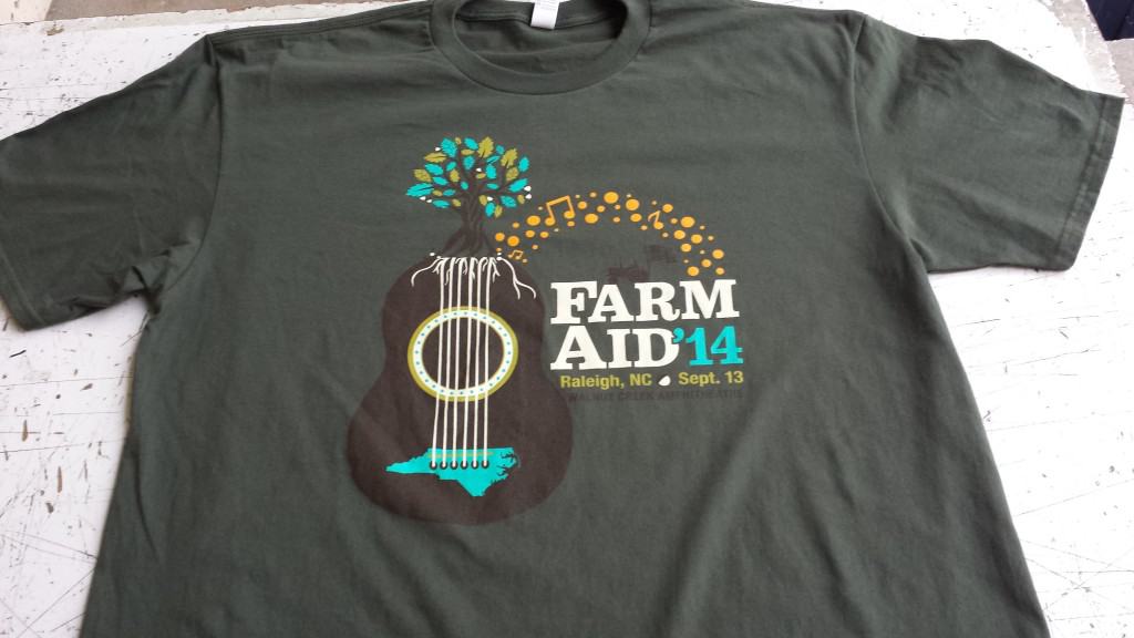 The shirt of the 2014 Farm Aid Logo Shirt uses the same elements as the poster but it specifically for the shirt design.